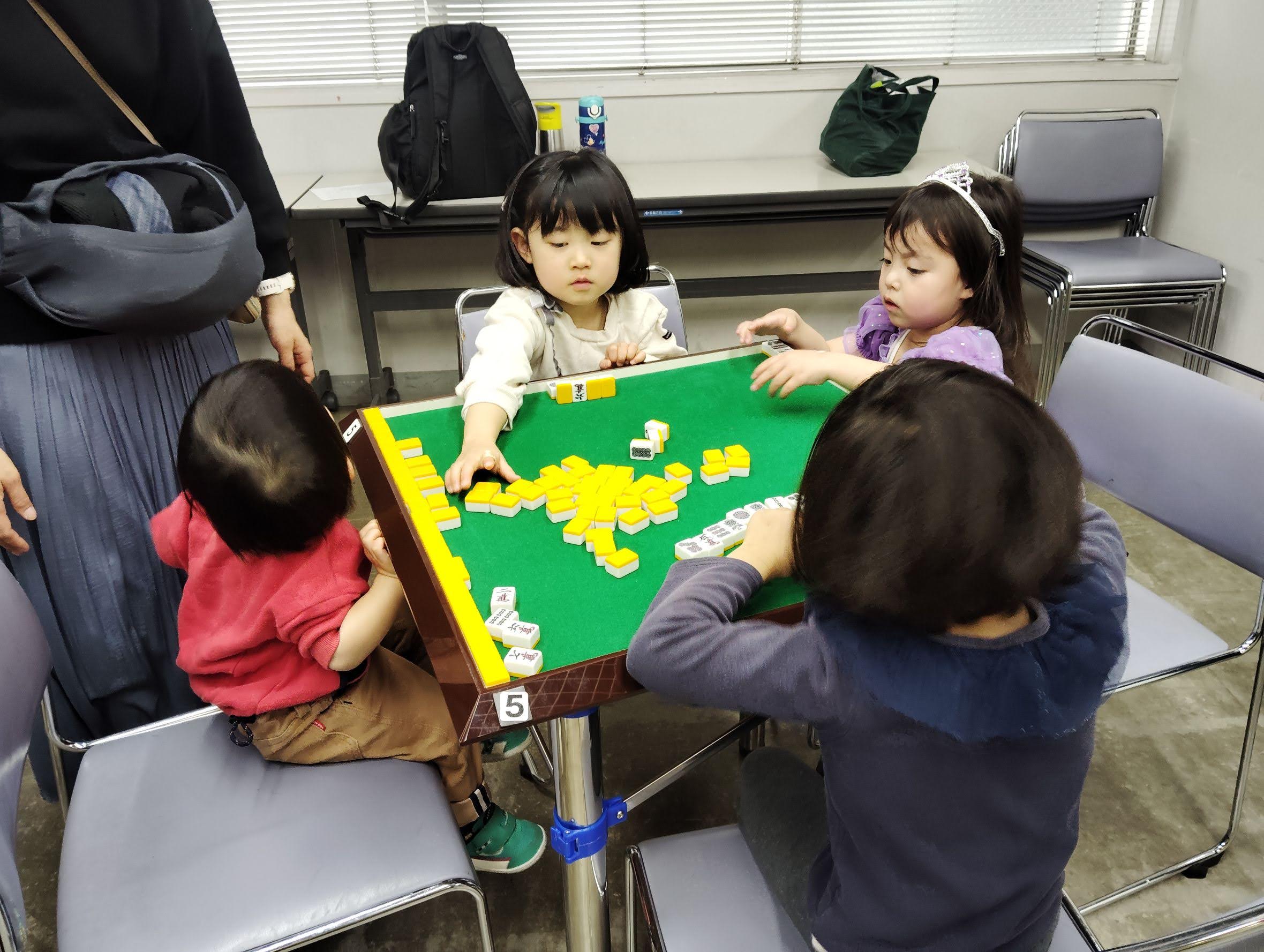 牌を並べながら笑顔を見せる子どもの様子