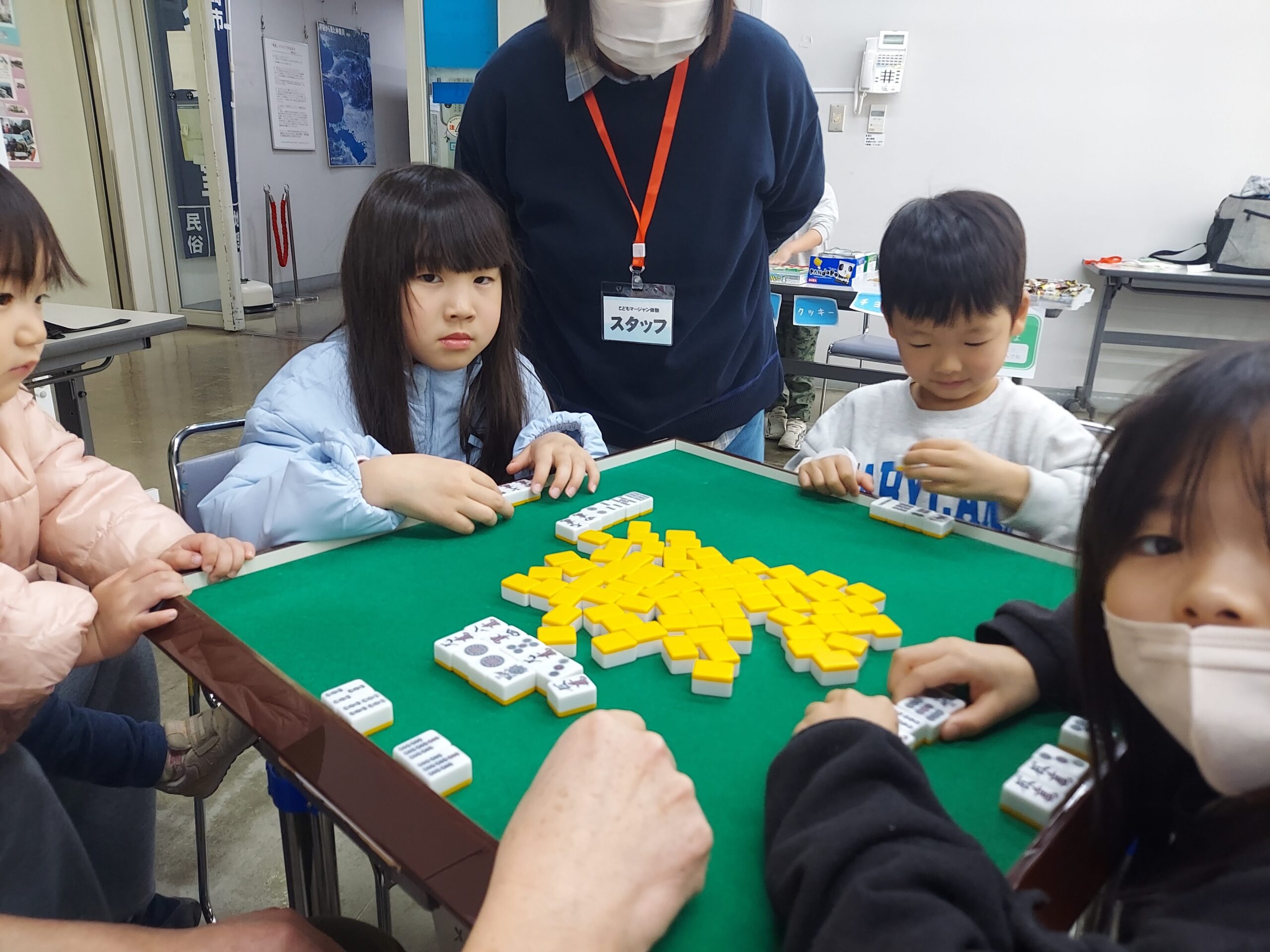こどもたちが卓を囲んでマージャンを楽しむ様子